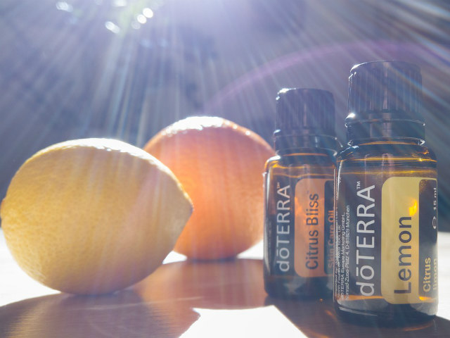 Two bottles of doterra oils next to an apple.